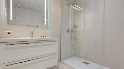 bagno bianco con lavandino e doccia di Mangia's Pollina Resort a Cefalù