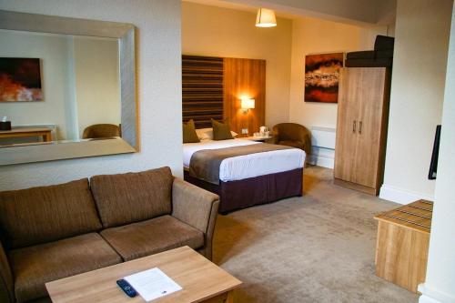 um quarto de hotel com uma cama e um sofá em Hillscourt em Barnt Green