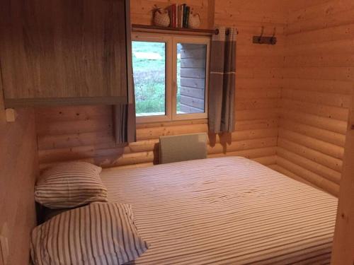 Tempat tidur dalam kamar di Lama-Gîte-des-Puys chalet écologique à 30km des pistes, visite aux lamas Charge VE
