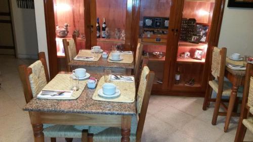 a dining room with two tables and chairs and a kitchen at Villa Floreal Hotel Boutique in Asuncion