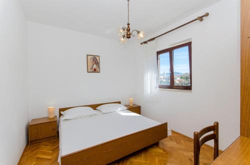 a bedroom with a bed and a window at Apartments Goran in Postira