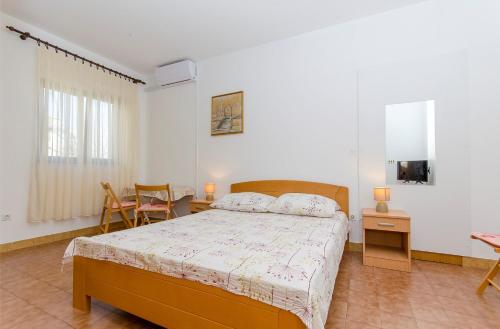 a bedroom with a bed and a table and chairs at Apartments Goran in Postira