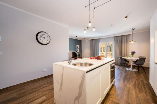 a kitchen with a sink and a clock on the wall at Doris Suites Sliema in Sliema