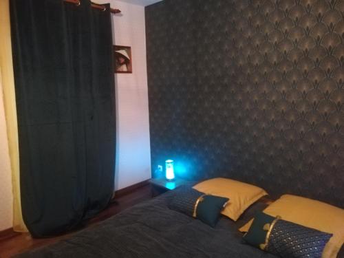 a bedroom with a bed with a blue light on it at Le Clos du Chêne in Langon