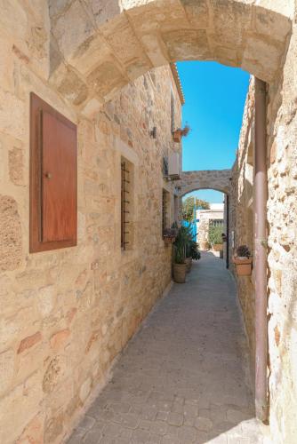 an alley in a stone building with an archway at Casa Di Veneto in Hersonissos