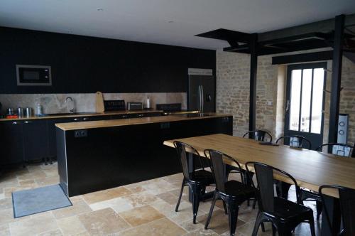 een keuken met een tafel en stoelen in een kamer bij l'atelier spa in Bayeux