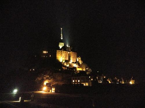 um castelo no topo de uma colina à noite em Au coeur de bourg... em Saint-Lunaire