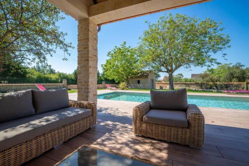 une terrasse avec deux chaises en osier et une piscine dans l'établissement 50 Nuances de Bourgogne, à Bligny-lès-Beaune