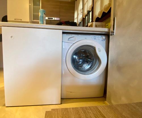 a white washing machine in a kitchen next to a counter at Bellagio Cool Flat - Private Parking & Rooftop terrace in Bellagio