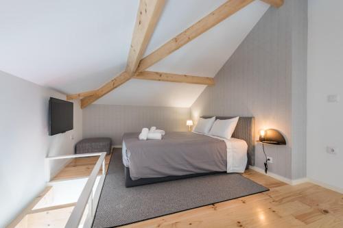 a bedroom with a bed and a flat screen tv at Sá de Noronha Mezzanine w Terrace in Porto