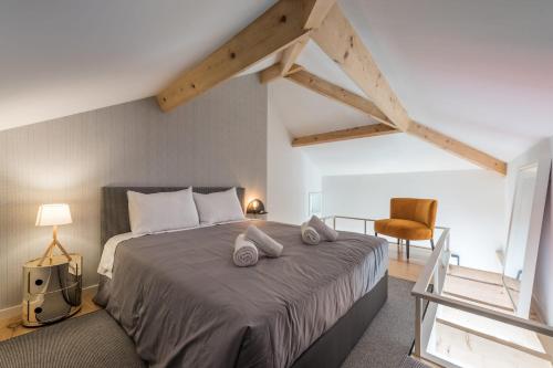 a bedroom with a large bed and a chair at Sá de Noronha Mezzanine w Terrace in Porto