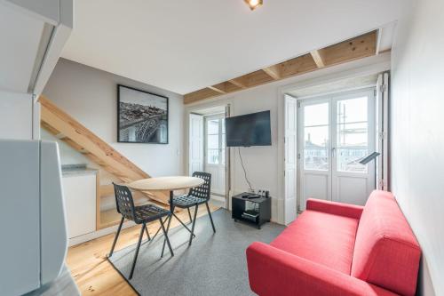 a living room with a red couch and a table at Sá de Noronha Mezzanine w Terrace in Porto