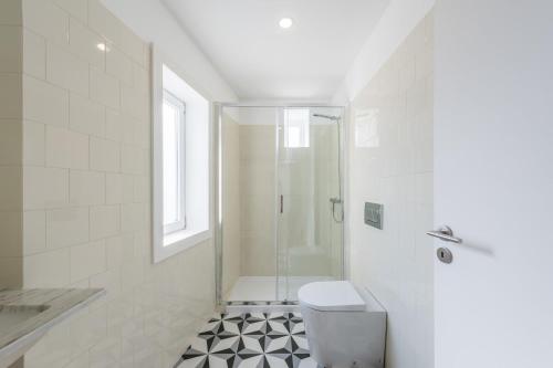 a white bathroom with a shower and a toilet at Sá de Noronha Mezzanine w Terrace in Porto
