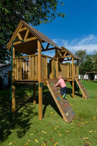 a young child playing on a wooden play structure at Lomond Woods Holiday Park in Balloch