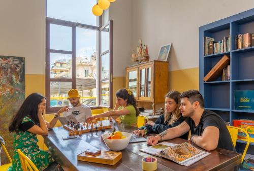un gruppo di persone seduti intorno a un tavolo in un ristorante di Intra Muros Hostel a Heraklion