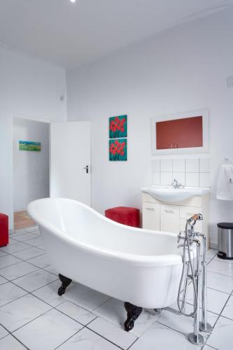 a white bath tub in a bathroom with a sink at Karoo Huisie Bethulie at Karoo Pandok in Bethulie