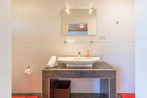 フーズムにあるImmenseeのバスルーム(洗面台、鏡付)
