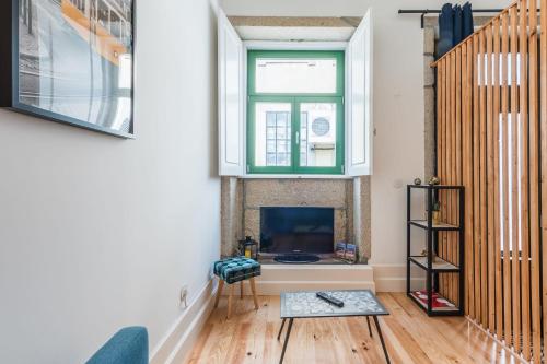 een woonkamer met een open haard en een raam bij GuestReady - Ladder Mezz in Porto