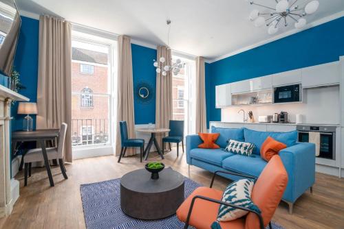 a living room with blue walls and a blue couch at 37 Doughty Street - Urban Apartments in London