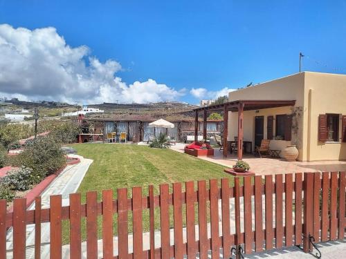a house with a fence in front of a yard at Vineyards Hill Villa in Megalokhori