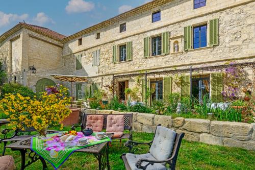 a garden with a table and chairs and a building at Bastide de Bellegarde in Avignon