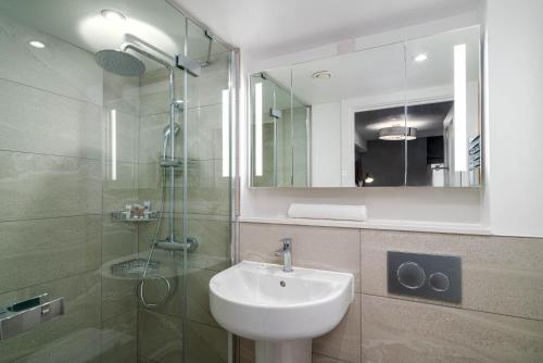 a bathroom with a sink and a shower with a mirror at 37 Doughty Street in London