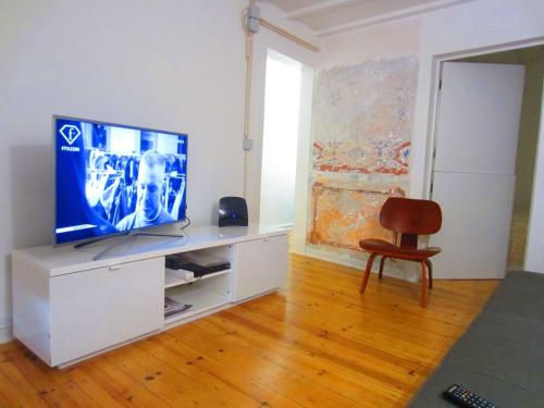 a living room with a television on a white cabinet at Largo da Paz 24 in Lisbon
