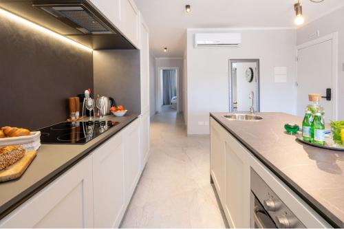 a kitchen with white cabinets and a counter top at Doris Suites Sliema in Sliema