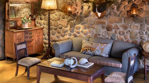 a living room with a couch and a table at Geiger's Camp in Timbavati Game Reserve by NEWMARK in Timbavati Game Reserve