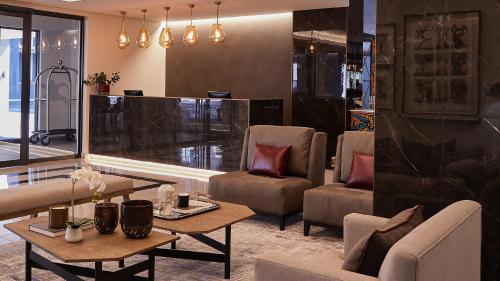 a living room with couches and a table and chairs at The Catalyst Apartment Hotel by NEWMARK in Johannesburg