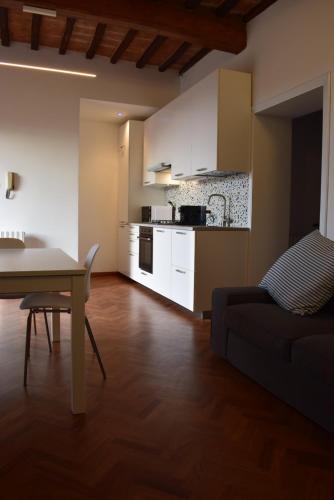 a kitchen and a living room with a table and a couch at Appartamento Ansidei 3 in Perugia