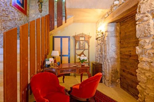 a room with a desk and two red chairs at Bastide de Bellegarde in Avignon