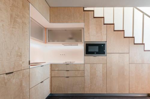 a kitchen with a staircase and a tv at Marques Design Apartments in Porto