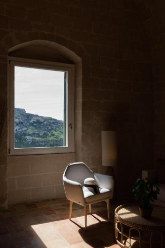 a chair sitting in a room with a window at Suite San Giacomo - L'Opera Dell'Architetto in Matera