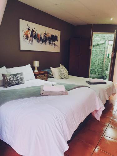 two beds sitting next to each other in a bedroom at Ay Jay's Guesthouse in Bloemfontein