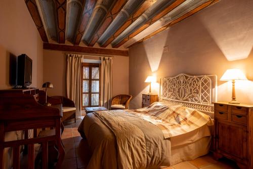 a bedroom with a bed and a desk and a piano at La Casa Grande in Talayuelas