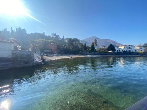 a body of water with the sun in the background at Bellagio Cool Flat - Private Parking & Rooftop terrace in Bellagio