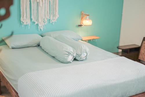 a bed with white sheets and pillows in a room at Abrakadabra 747 in Timuran