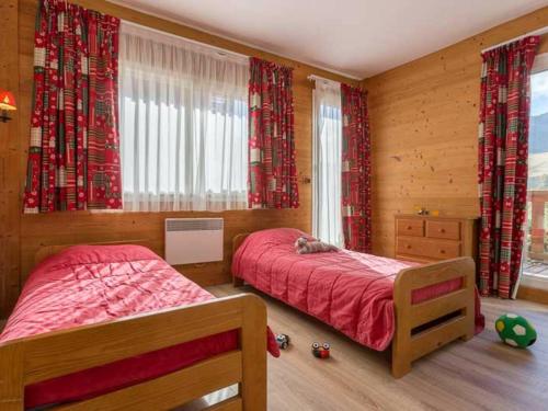 a bedroom with two beds and red curtains at Appartement Les Deux Alpes, 4 pièces, 10 personnes - FR-1-348-175 in Les Deux Alpes