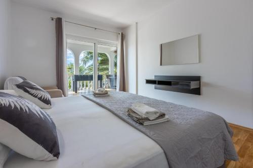 a bedroom with a large bed with a phone on it at Apartment Villa Zdenka in Crikvenica