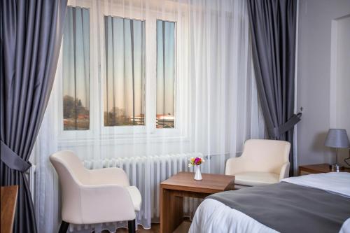 a hotel room with a bed and two chairs and a window at Kutlucan Oldtown in Bursa