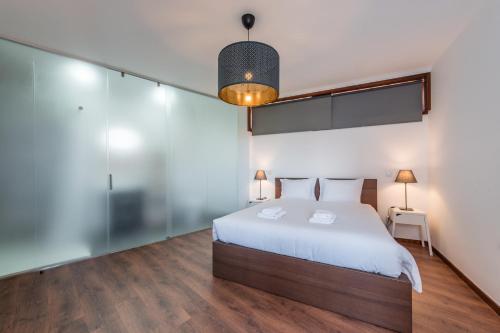 - une chambre avec un lit et un mur en verre dans l'établissement GuestReady - Redamancy Flat, à Porto