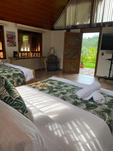a room with two beds and a television in it at Rancho Ecoturistico el Faro in La Mesa