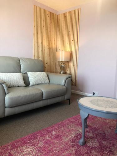 a living room with a couch and a table at Cranwell Court Apartments in Aberystwyth