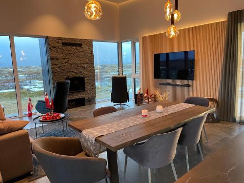 a living room with a large wooden table and chairs at Fögruvellir Country House in Hella