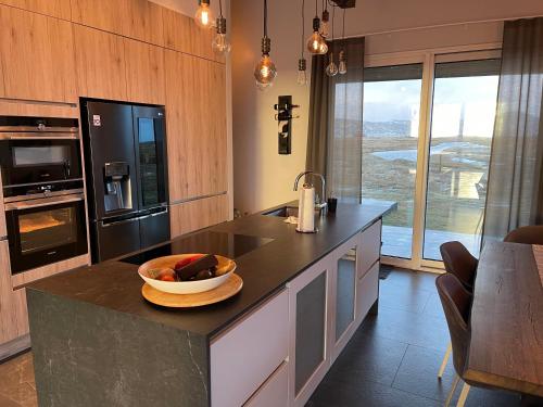 una cocina con una barra con un bol de fruta. en Fögruvellir Country House, en Hella