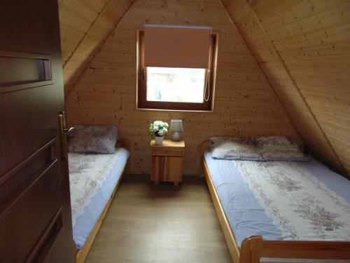 a bedroom with two beds in a log cabin at Domki KANZAS in Sławno