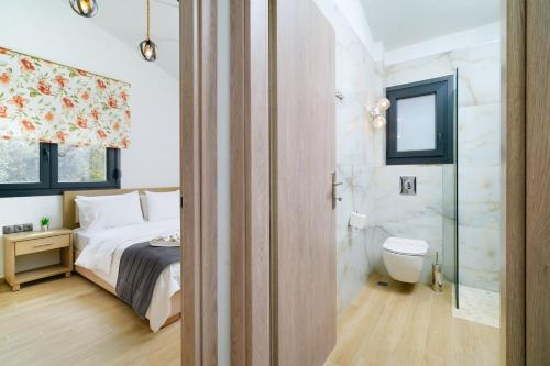 a bedroom with a bed and a shower and a toilet at Serenity Apartments in Skala Potamias