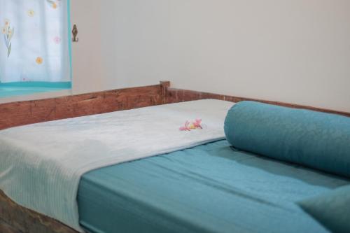 a bed with a pink flower on top of it at Abrakadabra 747 in Timuran