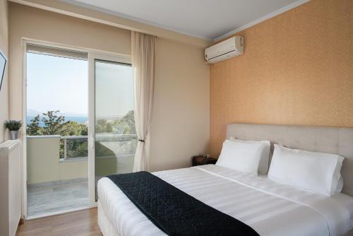 1 dormitorio con cama y ventana grande en Athenian Riviera Sea View Penthouse, en Vari